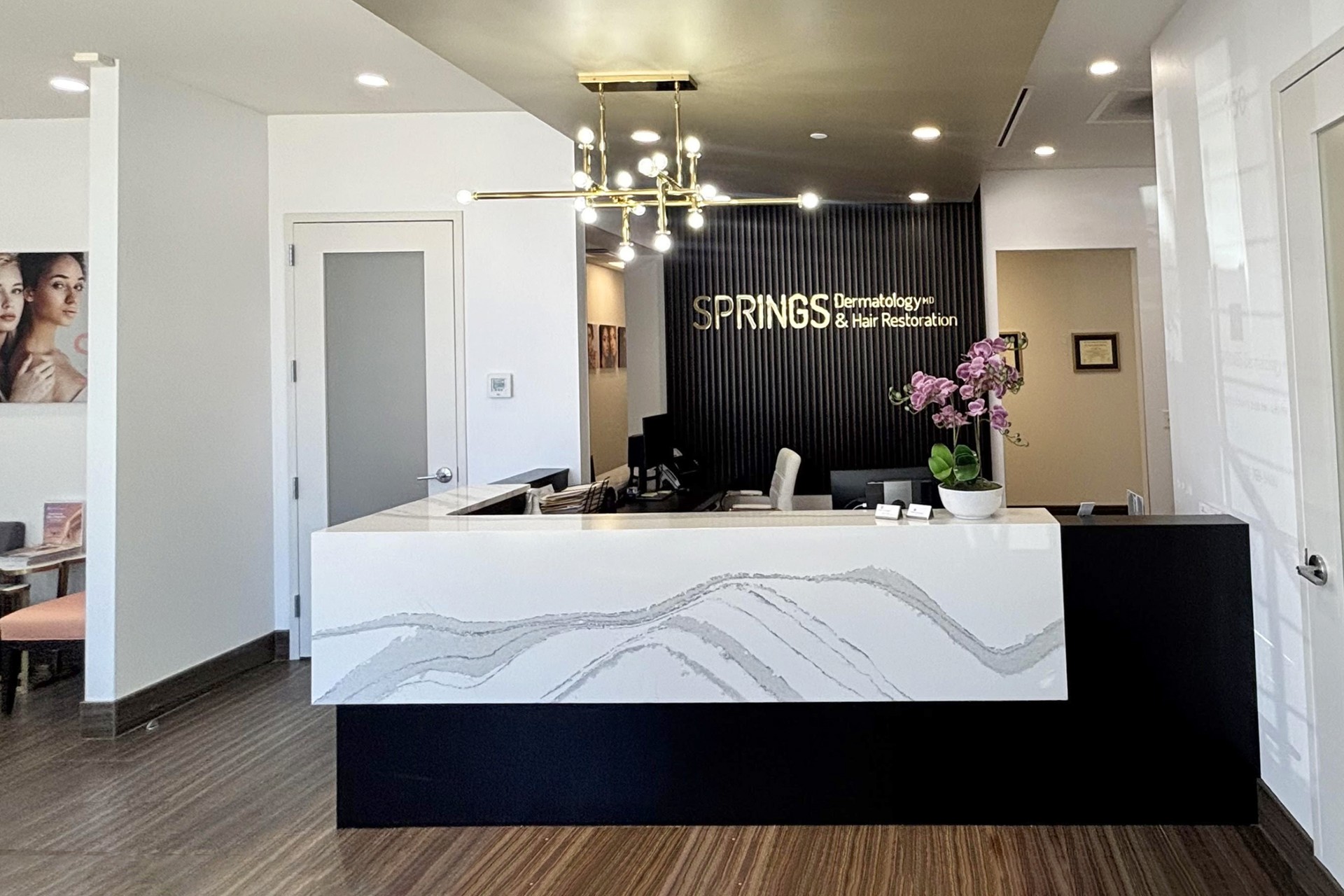 A friendly front desk welcomes patients in the modern, well-lit, and comfortable lobby of the Springs Hair Restoration.