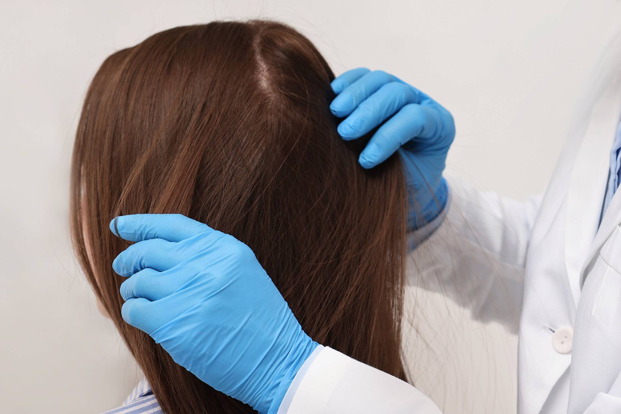 A man at home examining hair supplement for hair loss treatment.