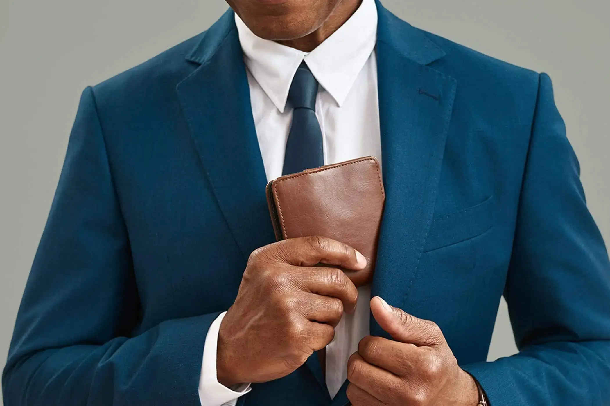 A man is reaching for his wallet to demonstrate financing plan options for a hair transplant.