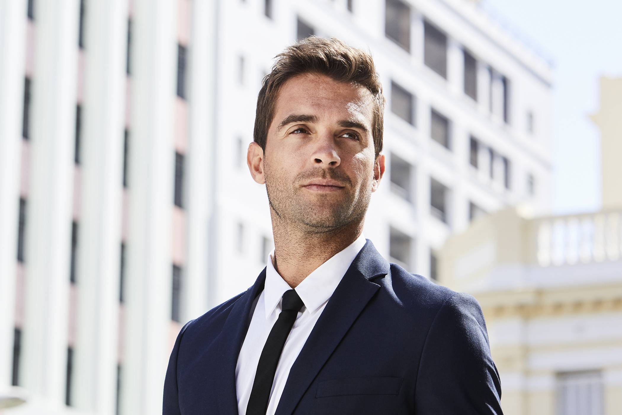 Confident man in suit outdoors, symbolizing natural results from a hair transplant in Atlanta.