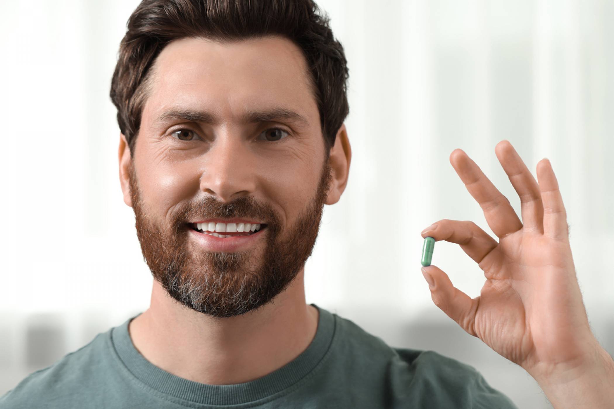 A man at home examining hair supplement for hair loss treatment.