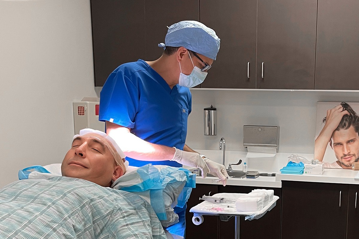 Hair transplant surgeon performing FUE procedure on a relaxed patient at Springs Hair Restoration in Atlanta