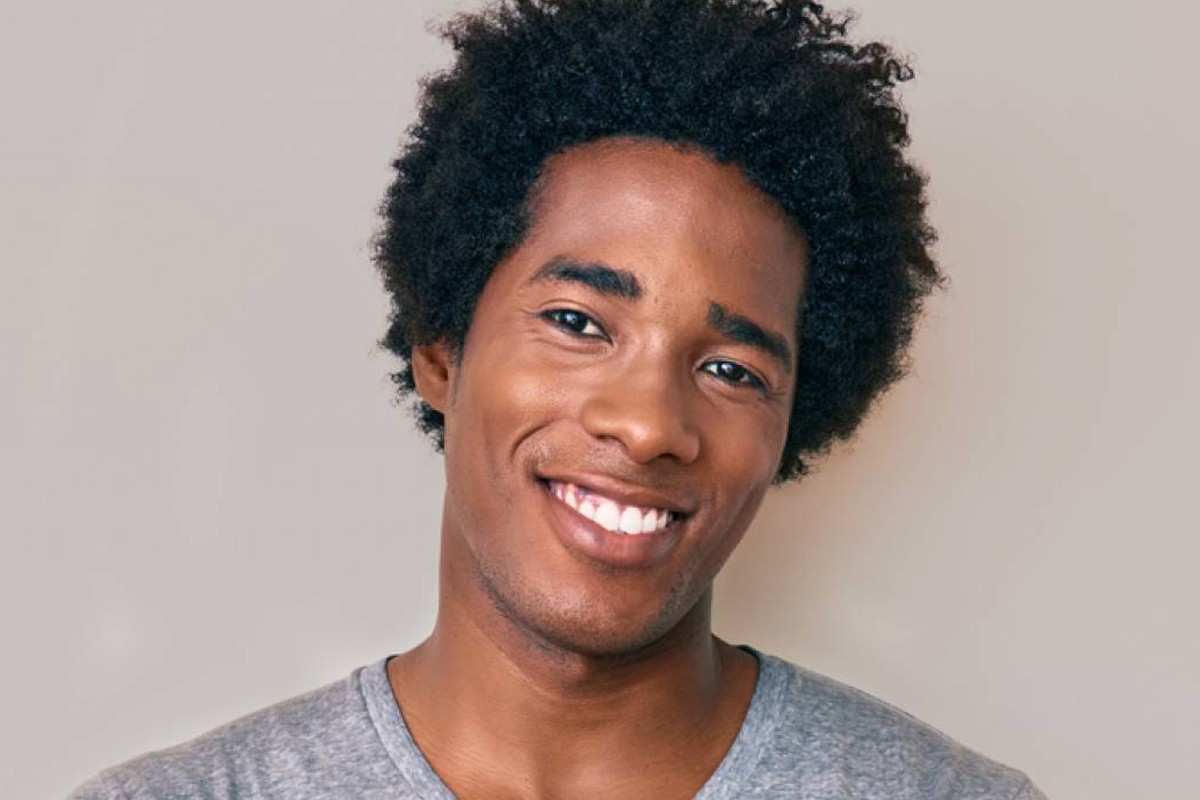 Smiling man with natural, healthy hair after FUE hair transplant for Black men in Atlanta