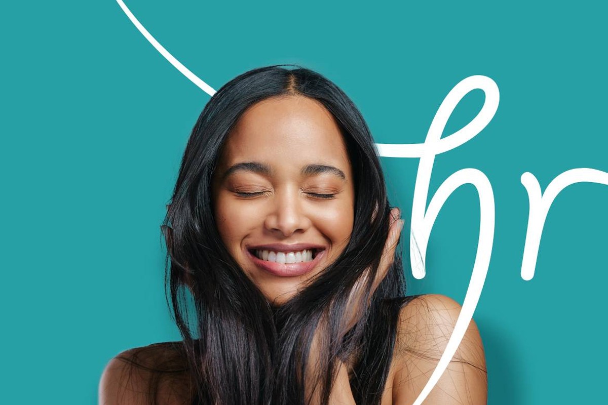 Smiling woman with healthy hair after non-surgical hair restoration.