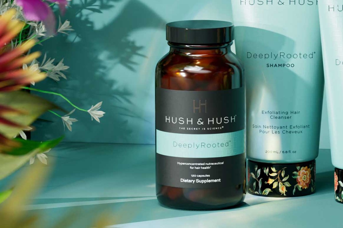 DeeplyRooted supplement bottle (Hush & Hush branding, blue accent band) with loose capsules arranged to the right on a clean backdrop.