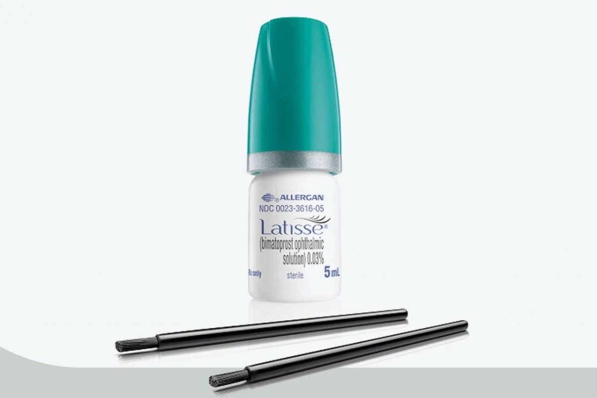 Bottle of Latisse eyelash growth serum with applicator brushes.